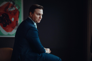 Svalner Atlaksen työntekijä istuu sohvalla ja katsoo eteenpäin.